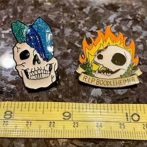 Two skull pins with crystals and flames